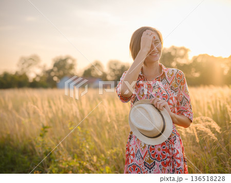 boho chic woman in a floral dress in European countryside 136518228