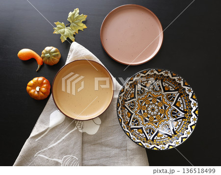 Multicolored ceramic plates and patterned bowl on black background. Design mockup. Food and traditional cuisine. Top view. 136518499