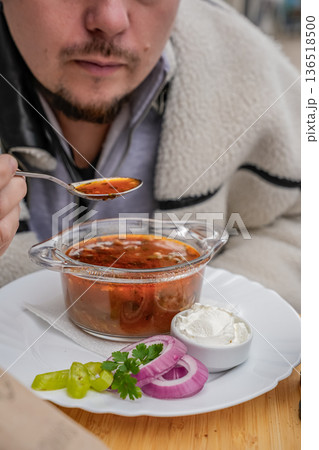 Man Eating Borscht Soup with Spoon 136518500