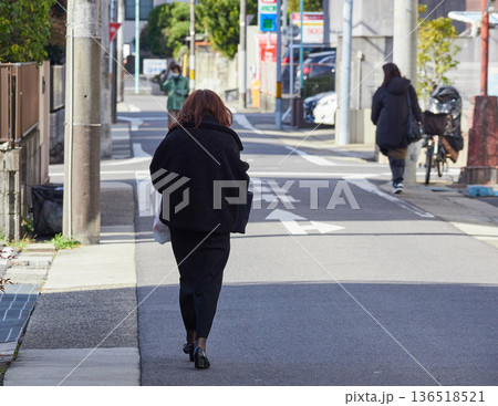 冬の昼の都市の住宅街で歩く中年女性の姿 冬の昼の都市の住宅街で歩く中年女性の姿 136518521