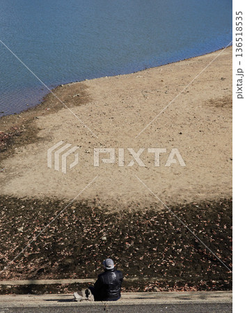 冬の公園の枯れた池の階段で座る一人のシニア男性の姿 冬の公園の枯れた池の階段で座る一人のシニア男性の姿 136518535
