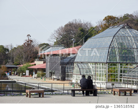 冬の昼の名古屋市の東山植物園で休憩する若者カップルの姿と温室の風景 冬の昼の名古屋市の東山植物園で休憩する若者カップルの姿と温室の風景 136518592
