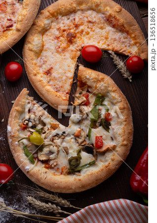 various of tasty fresh Pizza. served at wooden table with cherry tomatos and wheat ears. flat lay. various of tasty fresh Pizza. served at wooden table with cherry tomatos and wheat ears. flat lay. 136518656