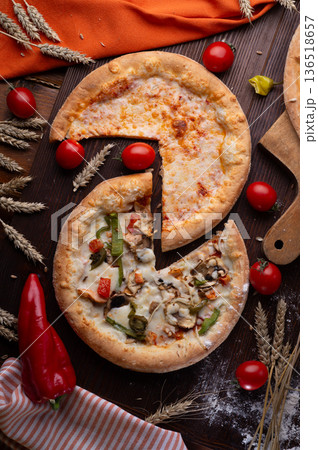 assortiment of tasty fresh Pizza. served at wooden table with cherry tomatos and wheat ears. flat lay. assortiment of tasty fresh Pizza. served at wooden table with cherry tomatos and wheat ears. flat lay. 136518657