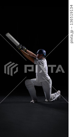 Cricket player kneeling and raising bat in powerful victory celebration Cricket player kneeling and raising bat in powerful victory celebration 136519134