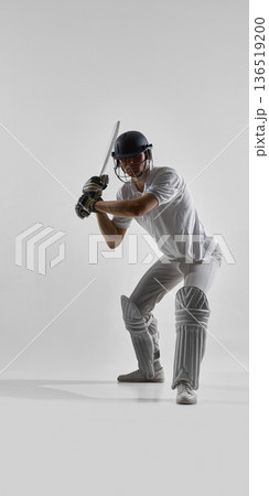 Cricket batsman in ready stance preparing to hit ball in studio, focused and determined. Cricket batsman in ready stance preparing to hit ball in studio, focused and determined. 136519200