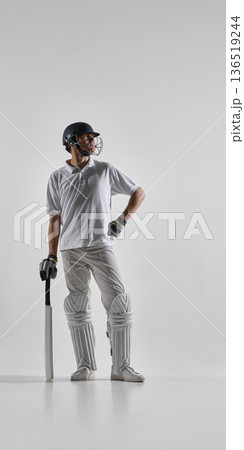 Cricket batsman standing with bat ready isolated on white background. 136519244