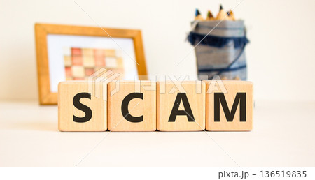 Scam symbol. Concept word Scam on beautiful wooden blocks. Beautiful picture frame and colored pencils. Beautiful white table white background. Business, lifestyle, support scam concept. Copy space. Scam symbol. Concept word Scam on beautiful wooden blocks. Beautiful picture frame and colored pencils. Beautiful white table white background. Business, lifestyle, support scam concept. Copy space. 136519835