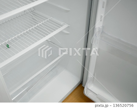 Open empty fridge with wire shelves and transparent door bins. Clean white refrigerator interior, modern kitchen appliance, cold storage concept with copy space Open empty fridge with wire shelves and transparent door bins. Clean white refrigerator interior, modern kitchen appliance, cold storage concept with copy space 136520756