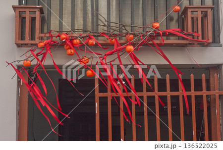 Traditional home decorations for the Lunar New Year celebration, tangerines and red ribbons Traditional home decorations for the Lunar New Year celebration, tangerines and red ribbons 136522025