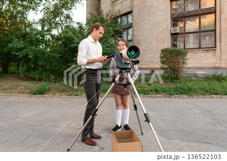 Student and instructor using smartphone to calibrate telescope outdoors Student and instructor using smartphone to calibrate telescope outdoors 136522103
