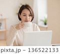 パソコン画面を見ながらコーヒーを飲む女性 136522133