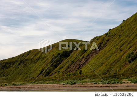 Grassy coastal hillside sloping gently toward shoreline Grassy coastal hillside sloping gently toward shoreline 136522296
