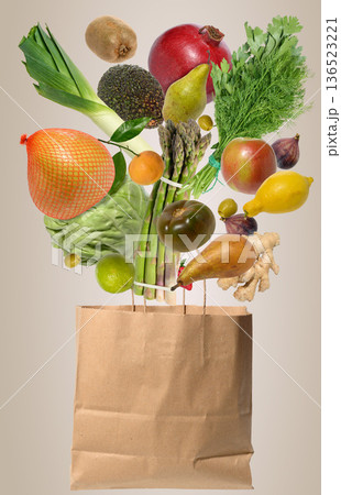 Levitating fresh vegetables and fruits flying out of a craft paper bag 136523221