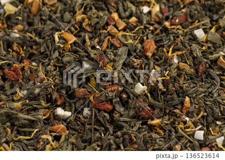 a large amount of dried green tea with the addition of natural flavors and pieces of fruits and berries, green tea with the addition of taste and smell of other sweet foods 136523614