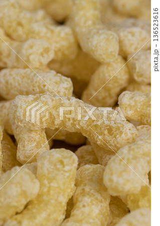 yellow large sweet sticks of corn with added sugar for quick cooking with milk or yogurt, ready-to-eat corn sticks scattered on food paper 136523616