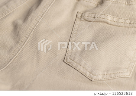 details of the beige fabric from which trousers or other clothes are sewn, close up details of the beige fabric from which trousers or other clothes are sewn, close up 136523618