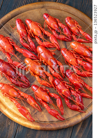 Top down boiled crawfish arranged on wooden board with lemon wedges, rustic background 136523927