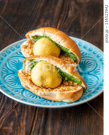 Authentic Vada Pav Indian street food with spicy chutney on rustic wooden background 136523942