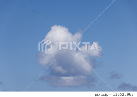 Single cumulus cloud floats in clear blue sky, a minimal daylight backdrop with wide copy space Single cumulus cloud floats in clear blue sky, a minimal daylight backdrop with wide copy space 136523965