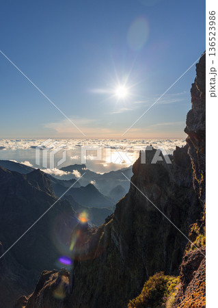 Vertical photo: Tourists watch sunrise from Pico do Arieiro terrace, Atlantic shines above clouds Vertical photo: Tourists watch sunrise from Pico do Arieiro terrace, Atlantic shines above clouds 136523986
