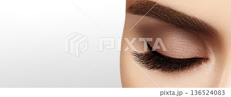 Beautiful macro shot of female eye with extreme long eyelashes and black liner makeup. Perfect shape make-up and long lashes. Cosmetics and make-up. Closeup macro shot of fashion eyes visage 136524083