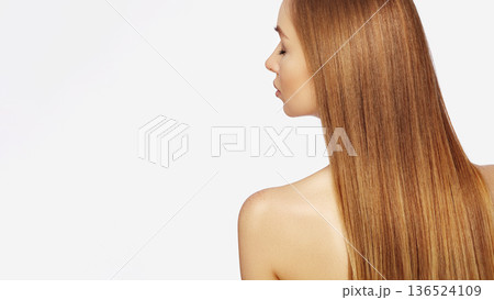 Beautiful young Woman with Long Straight dark Blond Hair. Fashion Model with Smooth Gloss Hairstyle on White Background. Keratin or Hair Botox Treatment. Beauty Salon, Shampoo, Balm or Serum Ad 136524109