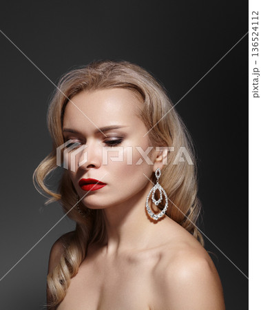 Glamorous CloseUp Blonde Woman Wearing Statement Earrings, Red Lipstick, Posing As Jewelry Model, Vintage Waves, Contemplative Gaze, Fashion Makeup, Wealth and Prosperity, Rich Woman in Luxury Style 136524112