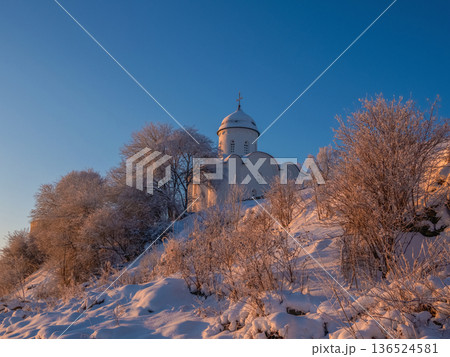 Beautiful church is in the background of a snowy landscape.. Beautiful church is in the background of a snowy landscape.. 136524581