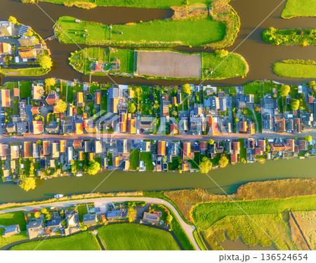 Aerial panoramic view of a traditional Dutch village with canals, houses and green farmland fields Aerial panoramic view of a traditional Dutch village with canals, houses and green farmland fields 136524654