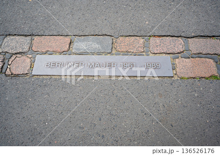 Berlin, germany, august 13, 2023. Berlin wall marker set into pavement tracing the former cold war border through the city, a solemn memorial of division and reunification Berlin, germany, august 13, 2023. Berlin wall marker set into pavement tracing the former cold war border through the city, a solemn memorial of division and reunification 136526176