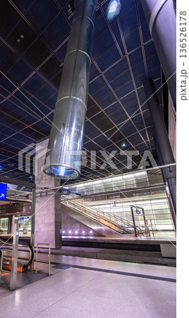 Berlin, germany, august 13, 2023. Underground train station with exposed ducts, concrete structures, and shining escalators connecting levels in a contemporary design Berlin, germany, august 13, 2023. Underground train station with exposed ducts, concrete structures, and shining escalators connecting levels in a contemporary design 136526178