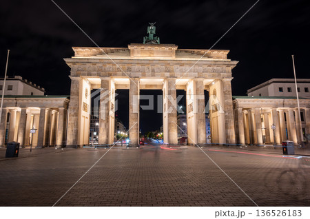 Berlin, germany, august 13, 2023. Brandenburg gate in berlin glowing against the night sky, neoclassical monument and symbol of german unity and history, empty street 136526183