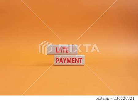 Late payment symbol. Concept word Late payment on wooden blocks. Beautiful orange background. Business and Late payment concept. Copy space 136526321