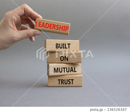 Leadership symbol. Wooden blocks with words Leadership Built on Mutual Trust. Businessman hand. Beautiful grey background. Business and Leadership concept. Copy space Leadership symbol. Wooden blocks with words Leadership Built on Mutual Trust. Businessman hand. Beautiful grey background. Business and Leadership concept. Copy space 136526387