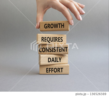 GROWTH symbol. Wooden blocks with words GROWTH REQUIRES CONSISTENT DAILY EFFORT. Beautiful grey background. Businessman hand. Business and GROWTH concept. Copy space GROWTH symbol. Wooden blocks with words GROWTH REQUIRES CONSISTENT DAILY EFFORT. Beautiful grey background. Businessman hand. Business and GROWTH concept. Copy space 136526389