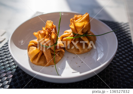 Traditional Russian crepes folded as khinkali pouches Traditional Russian crepes folded as khinkali pouches 136527832