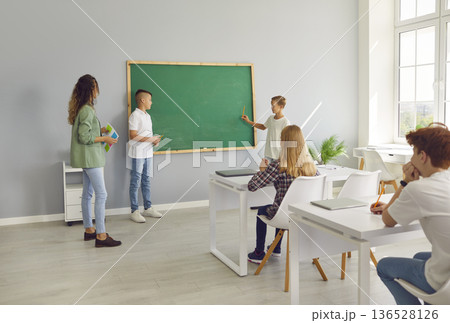 Students Answering At Chalkboard During Lesson 136528126