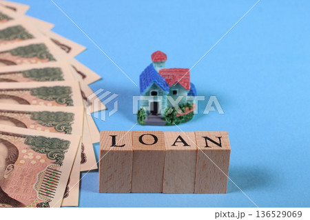 一万円札とミニチュアハウスとLOANの文字ブロック 水色背景(住宅ローン・融資のイメージ) 一万円札とミニチュアハウスとLOANの文字ブロック 水色背景(住宅ローン・融資のイメージ) 136529069