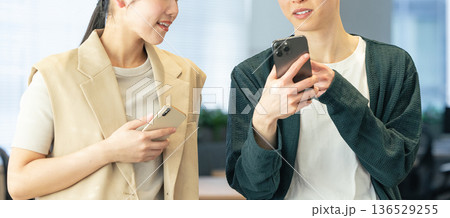 オフィスでスマホを使う男女 136529255