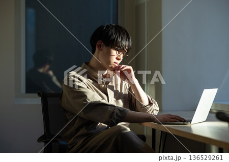 窓際で仕事をする男性 136529261