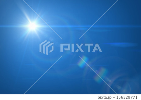Sun flare against clear blue sky. Solal lens flare and sky. 136529771
