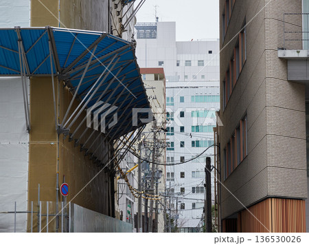 街のビルの工事現場の防音シートと落下防止の様子 街のビルの工事現場の防音シートと落下防止の様子 136530026