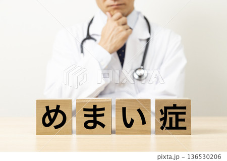 「めまい症」と書かれたブロックと悩む医師 136530206