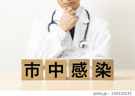 「市中感染」と書かれたブロックと悩む医師 「市中感染」と書かれたブロックと悩む医師 136530235