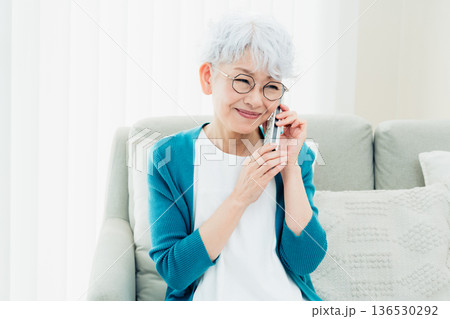 固定電話で通話するシニア女性 136530292