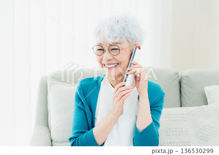 固定電話で通話するシニア女性 136530299