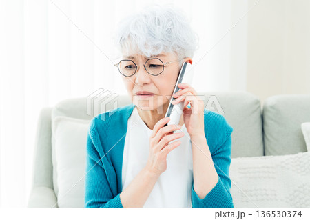 固定電話で通話するシニア女性 136530374