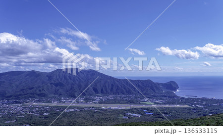 青空の下、八丈富士から望む三原山の山容と青い太平洋に囲まれた離島のパノラマ風景 136533115