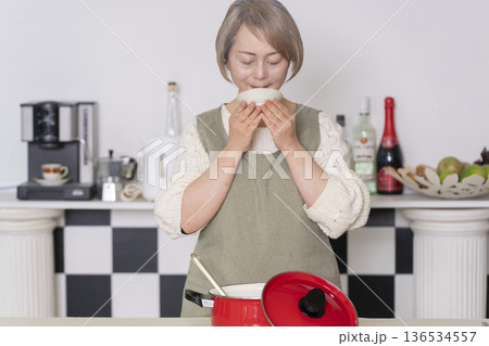 キッチンで作った料理の味見をするシニア女性 キッチンで作った料理の味見をするシニア女性 136534557
